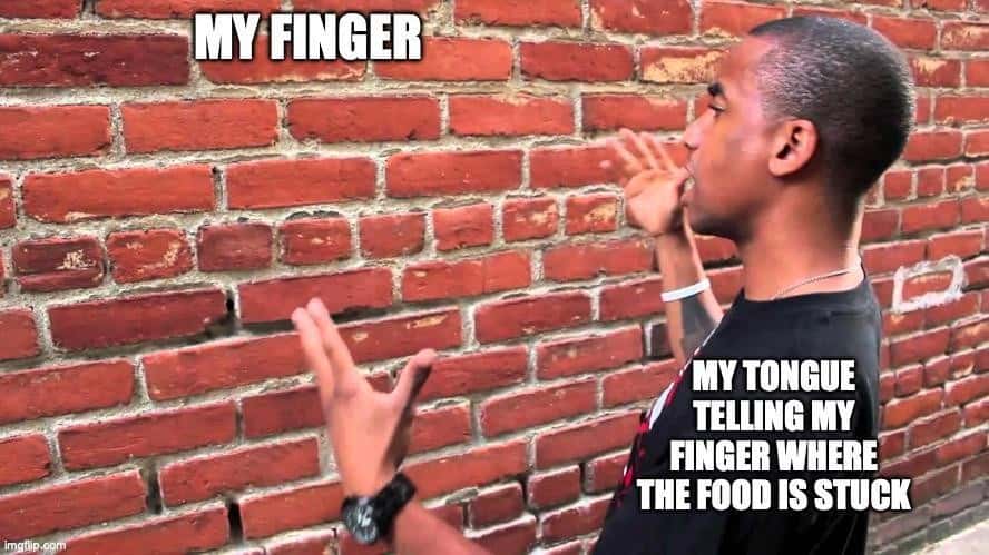Talking to a brick wall: Relatable meme of tongue guiding finger to stuck food Talking to a brick wall: Relatable meme of tongue guiding finger to stuck food
